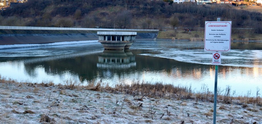 Teilweise zugefrorener Aartalsee mit Warnschild zu Lebensgefahr und Betreten der Eisfläche verboten.